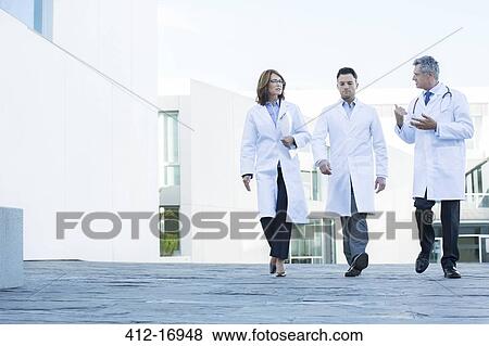 Doctors walking and talking on roof View Large Photo Image Stock Photo - Doctors walking and talking on roof. Fotosearch