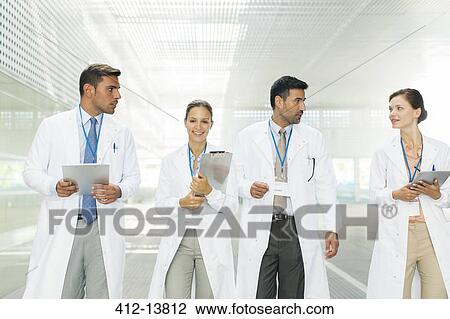 Doctors walking in hospital corridor View Large Photo Image Stock Image - Doctors walking in hospital corridor. Fotosearch