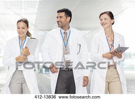 Doctors walking in hospital corridor View Large Photo Image Stock Photograph - Doctors walking in hospital corridor. Fotosearch