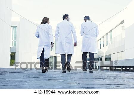 Picture - Doctors walking on rooftop. Fotosearch
