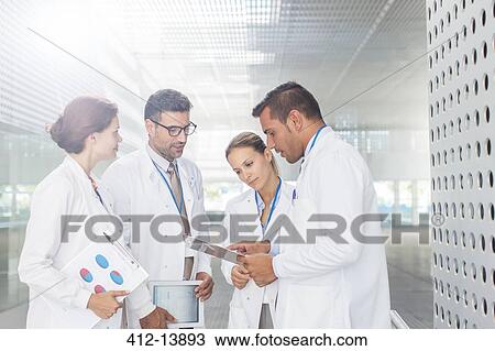 Doctors with clipboard talking in hospital corridor View Large Photo Image Stock Image - Doctors with clipboard talking in hospital corridor. Fotosearch