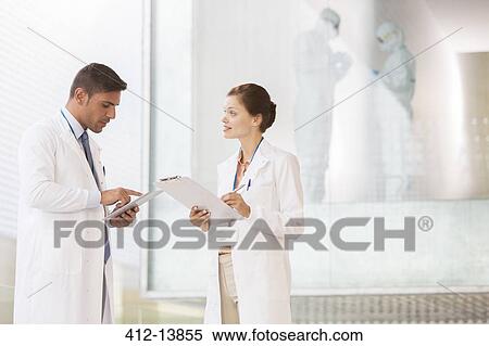 Stock Photography - Doctors with digital tablet and clipboard in hospital. Fotosearch