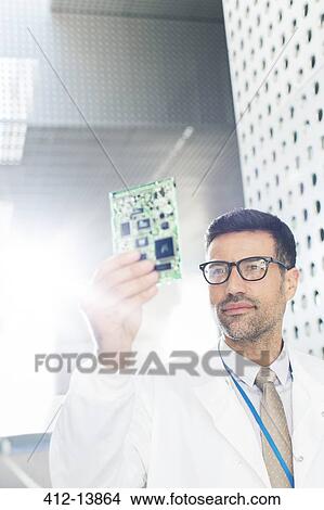 Picture - Engineer examining circuit board. Fotosearch