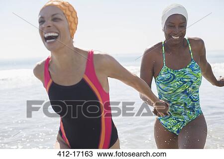 Stock Image - Enthusiastic lesbian couple at beach. Fotosearch