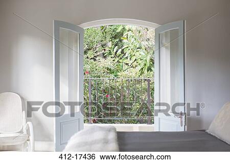French Doors Open To Balcony In Luxury Bedroom Stock Photograph