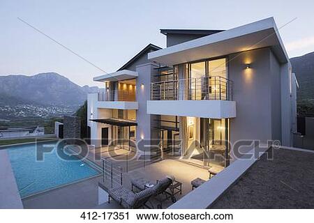 Stock Image - Modern house with swimming pool at dusk. Fotosearch