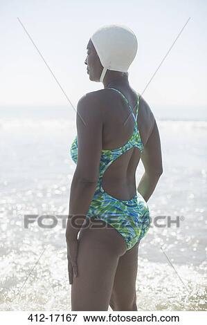 Pensive woman in bathing suit and cap at beach View Large Photo Image Stock Photo - Pensive woman in bathing suit and cap at beach. Fotosearch