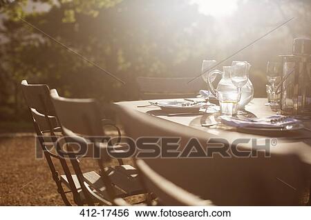 Place settings on sunny tranquil patio table View Large Photo Image Stock Photograph - Place settings on sunny tranquil patio table. Fotosearch