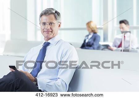 Portrait of businessman texting at airport View Large Photo Image Stock Image - Portrait of businessman texting at airport. Fotosearch