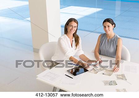 Stock Photo - Portrait of businesswomen at conference table. Fotosearch