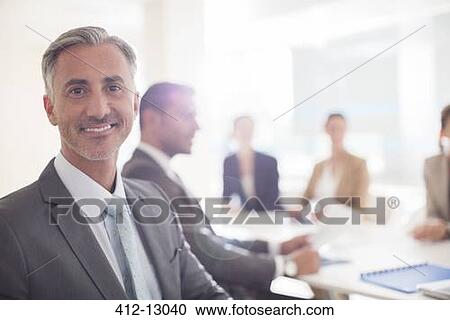 Stock Image - Portrait of confident businessman in conference room. Fotosearch
