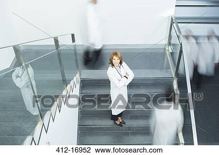 Portrait of confident doctor on staircase View Large Photo Image Stock Image - Portrait of confident doctor on staircase. Fotosearch