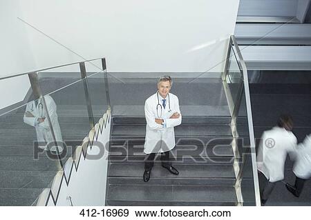 Portrait of confident doctor on staircase View Large Photo Image Stock Photo - Portrait of confident doctor on staircase. Fotosearch