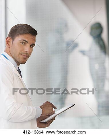 Portrait of confident doctor using digital tablet View Large Photo Image Picture - Portrait of confident doctor using digital tablet. Fotosearch