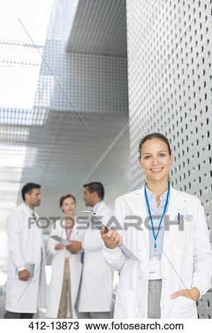 Portrait of confident doctor with clipboard in hospital corridor View Large Photo Image Stock Image - Portrait of confident doctor with clipboard in hospital corridor. Fotosearch