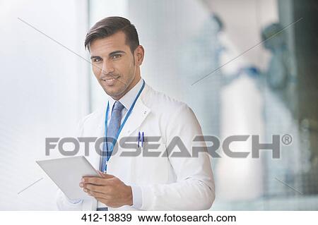 Portrait of confident doctor with digital tablet View Large Photo Image Stock Photo - Portrait of confident doctor with digital tablet. Fotosearch
