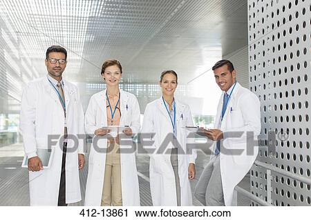 Portrait of confident doctors in hospital corridor View Large Photo Image Stock Image - Portrait of confident doctors in hospital corridor. Fotosearch