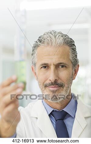 Portrait of confident scientist holding tube with green liquid View Large Photo Image Stock Image - Portrait of confident scientist holding tube with green liquid. Fotosearch