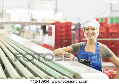 Picture - Portrait of confident worker in food processing plant. Fotosearch