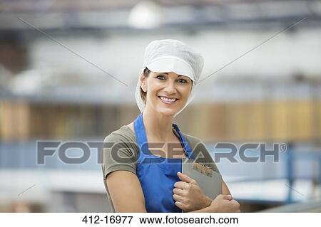 Stock Photo - Portrait of confident worker in food processing plant. Fotosearch
