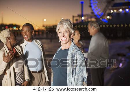 Portrait of enthusiastic senior woman with friends on beach at night View Large Photo Image Stock Photography - Portrait of enthusiastic senior woman with friends on beach at night. Fotosearch