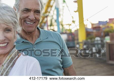 Stock Photo - Portrait of senior couple at amusement park. Fotosearch