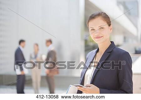 Portrait of smiling businesswoman with cell phone outdoors View Large Photo Image Stock Photo - Portrait of smiling businesswoman with cell phone outdoors. Fotosearch