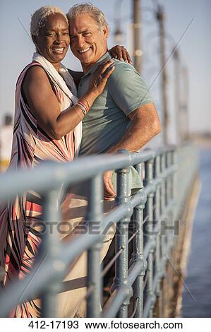 Portrait of smiling senior couple hugging on pier View Large Photo Image Stock Image - Portrait of smiling senior couple hugging on pier. Fotosearch