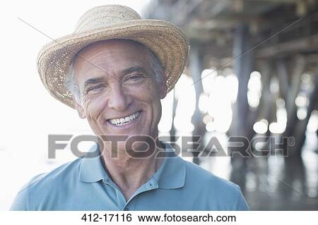 Portrait of smiling senior man in sun hat at beach View Large Photo Image Stock Photograph - Portrait of smiling senior man in sun hat at beach. Fotosearch