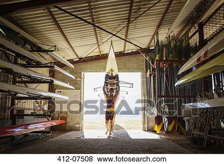 Rowing team carrying scull into shed View Large Photo Image Stock Photo - Rowing team carrying scull into shed. Fotosearch