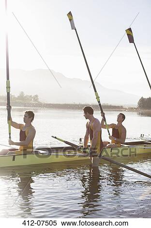 Rowing team lifting oars in lake View Large Photo Image Stock Photography - Rowing team lifting oars in lake. Fotosearch