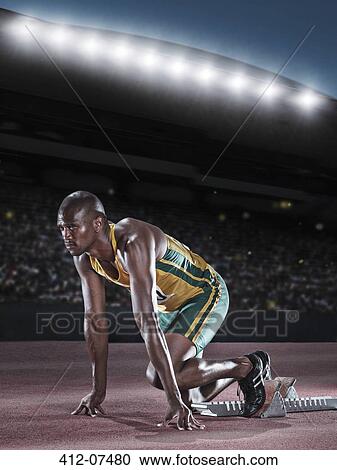 Runner poised at starting block on track View Large Photo Image Stock Image - Runner poised at starting block on track. Fotosearch
