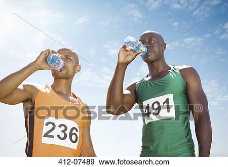 Runners drinking water on track View Large Photo Image Stock Photo - Runners drinking water on track. Fotosearch