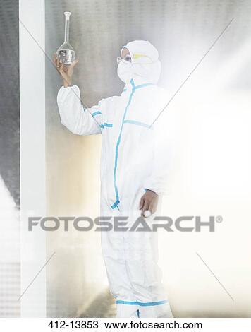 Scientist in clean suit examining liquid in beaker View Large Photo Image Stock Image - Scientist in clean suit examining liquid in beaker. Fotosearch