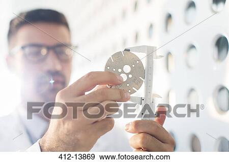Stock Photo - Scientist using calipers. Fotosearch