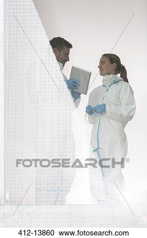 Scientists in clean suits with digital tablet View Large Photo Image Stock Image - Scientists in clean suits with digital tablet. Fotosearch