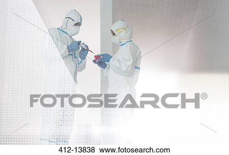 Stock Photo - Scientists in clean suits working in laboratory. Fotosearch