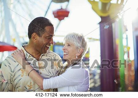 Senior couple hugging at amusement park View Large Photo Image Picture - Senior couple hugging at amusement park. Fotosearch
