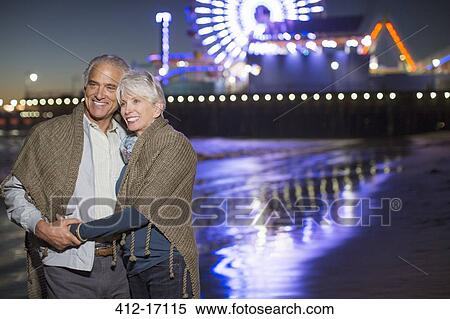 Senior couple hugging on beach at night View Large Photo Image Stock Photography - Senior couple hugging on beach at night. Fotosearch