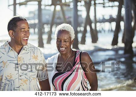 Senior couple on beach near pier View Large Photo Image Stock Image - Senior couple on beach near pier. Fotosearch
