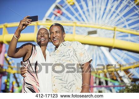 Senior couple taking selfie at amusement park View Large Photo Image Stock Image - Senior couple taking selfie at amusement park. Fotosearch