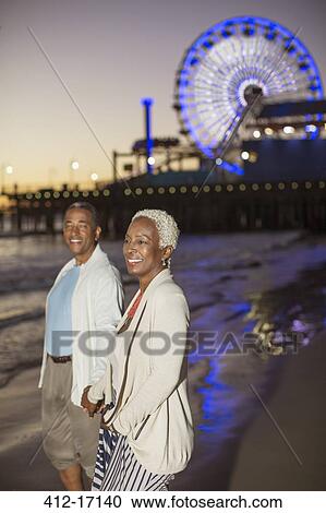 Senior couple walking on beach at sunset View Large Photo Image Stock Image - Senior couple walking on beach at sunset. Fotosearch