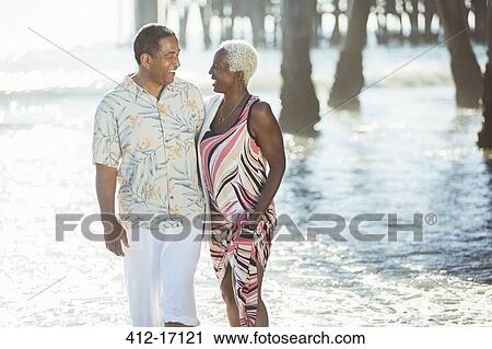 Senior couple walking on sunny beach View Large Photo Image Stock Image - Senior couple walking on sunny beach. Fotosearch