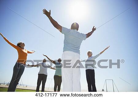 Seniors practicing yoga under sunny blue sky View Large Photo Image Stock Photo - Seniors practicing yoga under sunny blue sky. Fotosearch