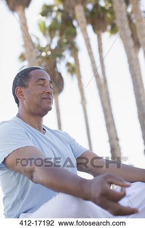 Serene senior man meditating in lotus position outdoors View Large Photo Image Stock Image - Serene senior man meditating in lotus position outdoors. Fotosearch