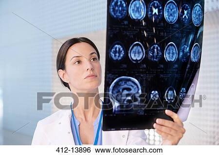 Serious doctor examining brain scan View Large Photo Image Stock Photograph - Serious doctor examining brain scan. Fotosearch
