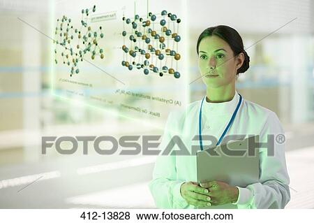 Stock Photo - Serious doctor with clipboard in hospital corridor. Fotosearch