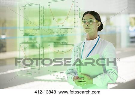 Stock Photo - Serious doctor with clipboard in hospital. Fotosearch