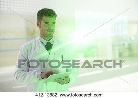 Stock Image - Serious doctor with digital tablet in hospital. Fotosearch