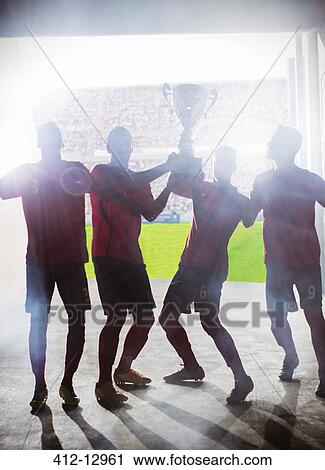 Silhouette of soccer players holding trophy View Large Photo Image Stock Image - Silhouette of soccer players holding trophy. Fotosearch